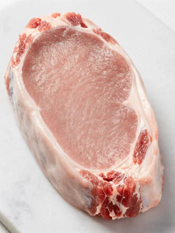 Pedaços frescos de carne de vitela clara com especiarias em tábua de madeira