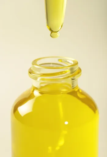 Óleo de limão em frasco pequeno, com rodelas de limão e raspas