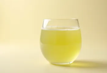 Soro de leite em garrafa e prato sobre superfície de madeira clara, luz natural