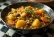 Sambar com legumes mistos servido ao lado de arroz e acompanhamento de legumes