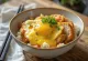Katsudon de legumes e caril com frango em massa crocante servido com coentros frescos