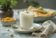Lassi de cardamomo em copo, decorado com cubos de gelo e um pouco de cardamomo