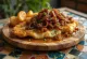 Cachopo com cebola caramelizada, carne panada estaladiça recheada com queijo, servida com cebola doce