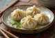 Jiaozi chinês servido, cozido, em prato de porcelana claro