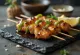 Yakitori clássico frango grelhado no espeto servido com sementes de sésamo e cebolinho fresco
