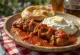 Kebab Iskender com molho de tomate picante, servido com molho de iogurte e alho e pão pita tostado