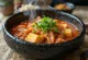 Sopa kimchi jjigae a ferver numa panela de pedra preta