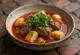 Thareed com carne fumada, servido com coentros frescos, com cubos de pão