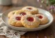 Biscoitos linzer recheados com compota, polvilhados com açúcar em pó.