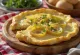 Welsh rarebit com alho-francês servido, em molho de queijo, sobre torrada, com pedaços frescos de alho-francês