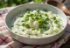 Raita de ervilhas e menta servida, decorada com menta fresca e ervilhas
