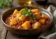 Aloo Tamatar Sabzi numa tigela, decorado com coentros frescos