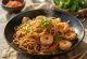 Yakisoba com camarão, mistura deliciosa de massa e legumes com camarão e sementes de sésamo