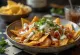 Chilaquiles com Crema Mexicana, pedaços de tortilha crocantes com molho de tomate e coentros frescos