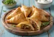 Samsa triangular dourada e folhada num prato